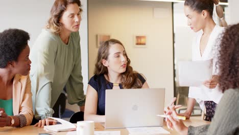 Diversas-Mujeres-De-Negocios-Reuniéndose-Y-Usando-Una-Computadora-Portátil-En-La-Oficina,-En-Cámara-Lenta