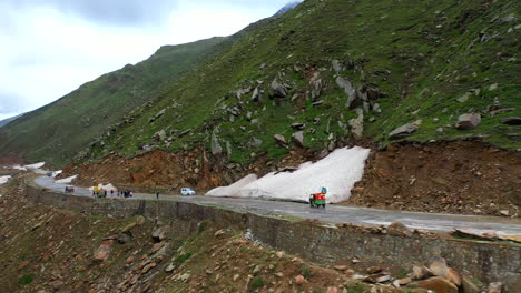 Toma-De-Drone-De-Un-Tuk-Tuk-En-El-Paso-De-Montaña-Del-Paso-De-Babusar-En-Pakistán,-Con-Algunos-Vehículos-En-La-Carretera-En-El-Valle-De-Kaghan,-Que-Revela-Una-Toma-Amplia