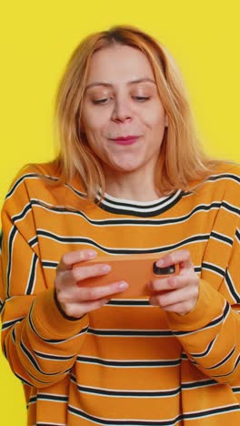 happy woman playing racing drive simulator shooter video games on smartphone celebrate victory win