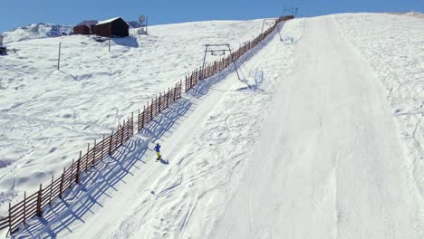 tracking aerial orbit of a person ascending with the drag lift on the slopes of the farellones ski park, chile