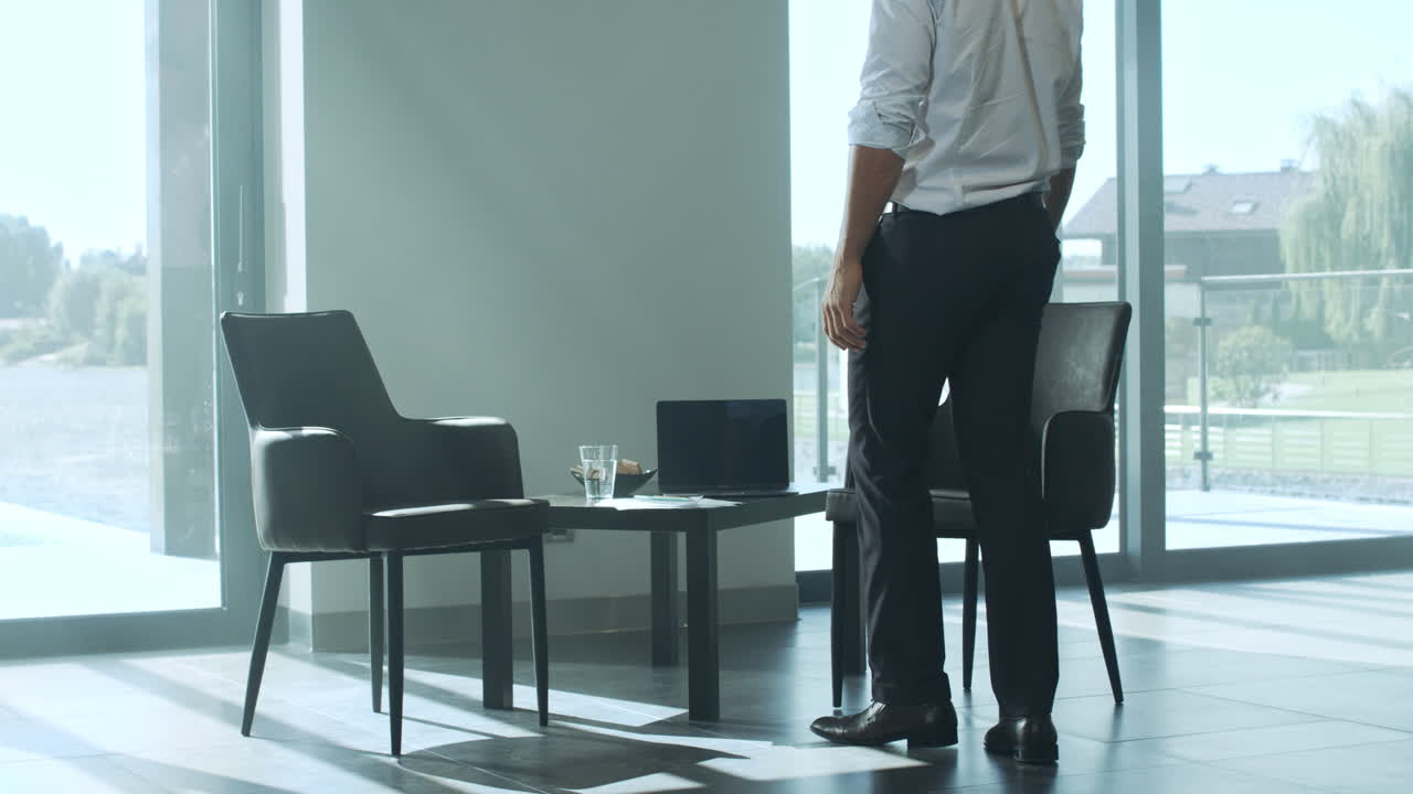 hombre de negocios casual sentado en una silla en una casa de lujo. hombre rico trabajando en casa