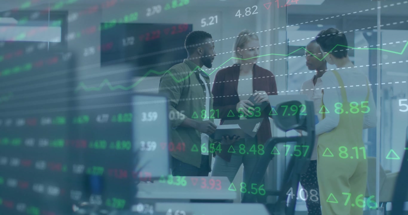 Man in green coat initiating data analysis on tablet at console with financial tickers guiding team