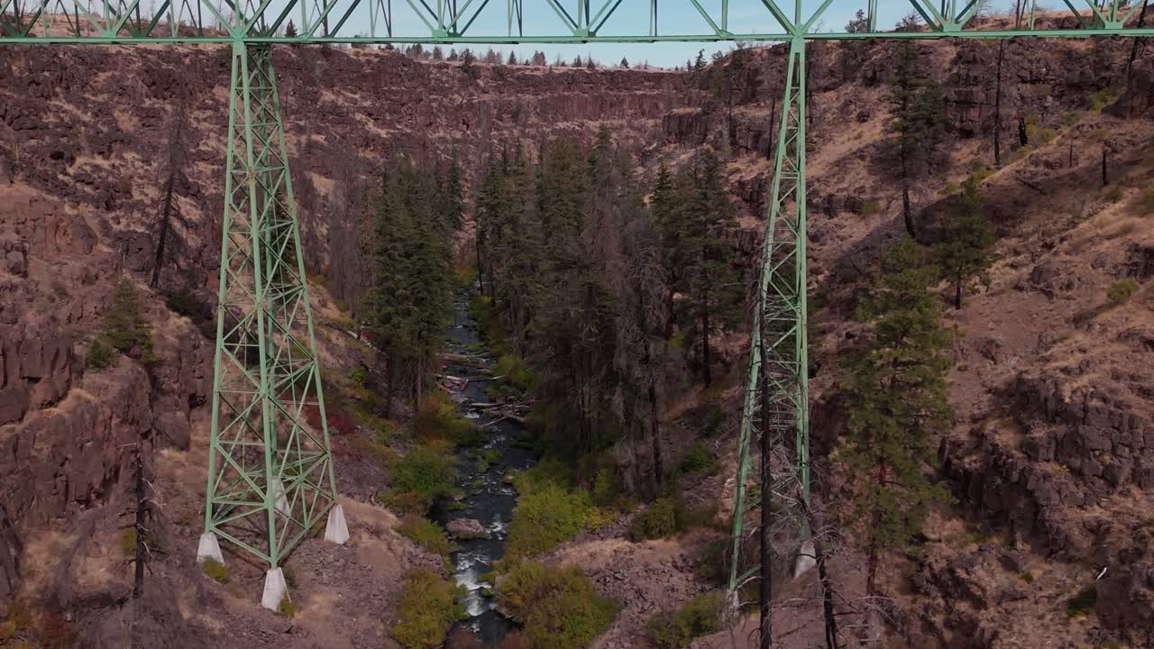 Drone pull back and climb to reveal Mill Creek bridge in Warm Springs Oregon