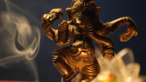 estatua de ganesha con luces de vela y humo de incienso de cerca 11