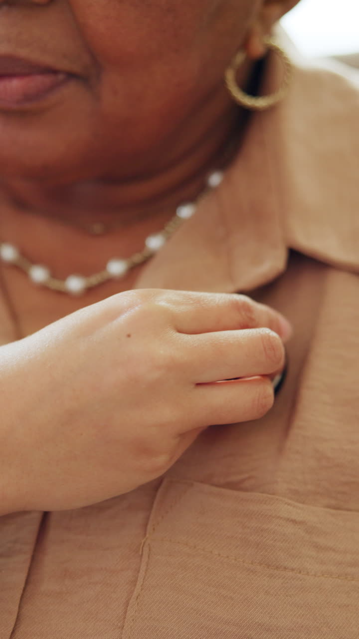 Close-up of a Person's Hand Adjusting a Button on a Brown Shirt