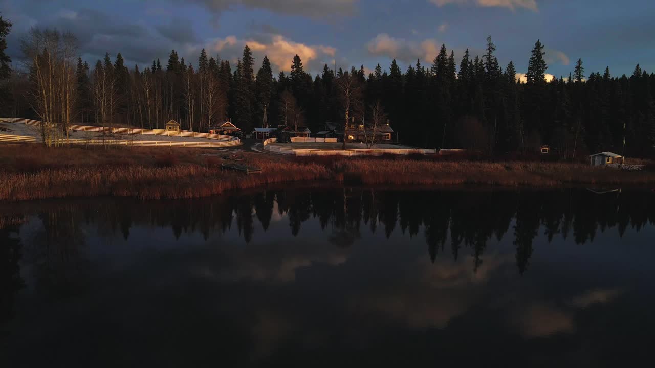 Magnifica ripresa d'avvicinamento sul lago Glimpse in Columbia Britannica, Canada, splendidi riflessi del cielo nell'acqua, luce dell'ora d'oro, foresta di abeti, home ranch.