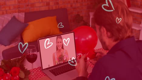 Heart-icons-over-caucasian-man-showing-a-ring-while-having-a-video-call-on-laptop