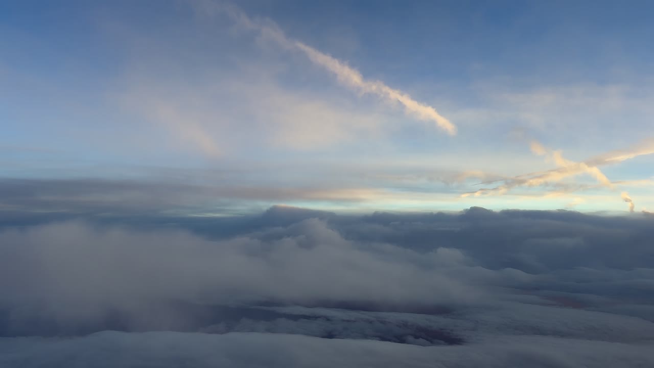 Vista aérea de muchas estelas de condensación de color dorado que se difuminan en un cielo de múltiples capas al amanecer. Vídeo grabado desde la cabina de un jet que vuela en la atmósfera superior.
