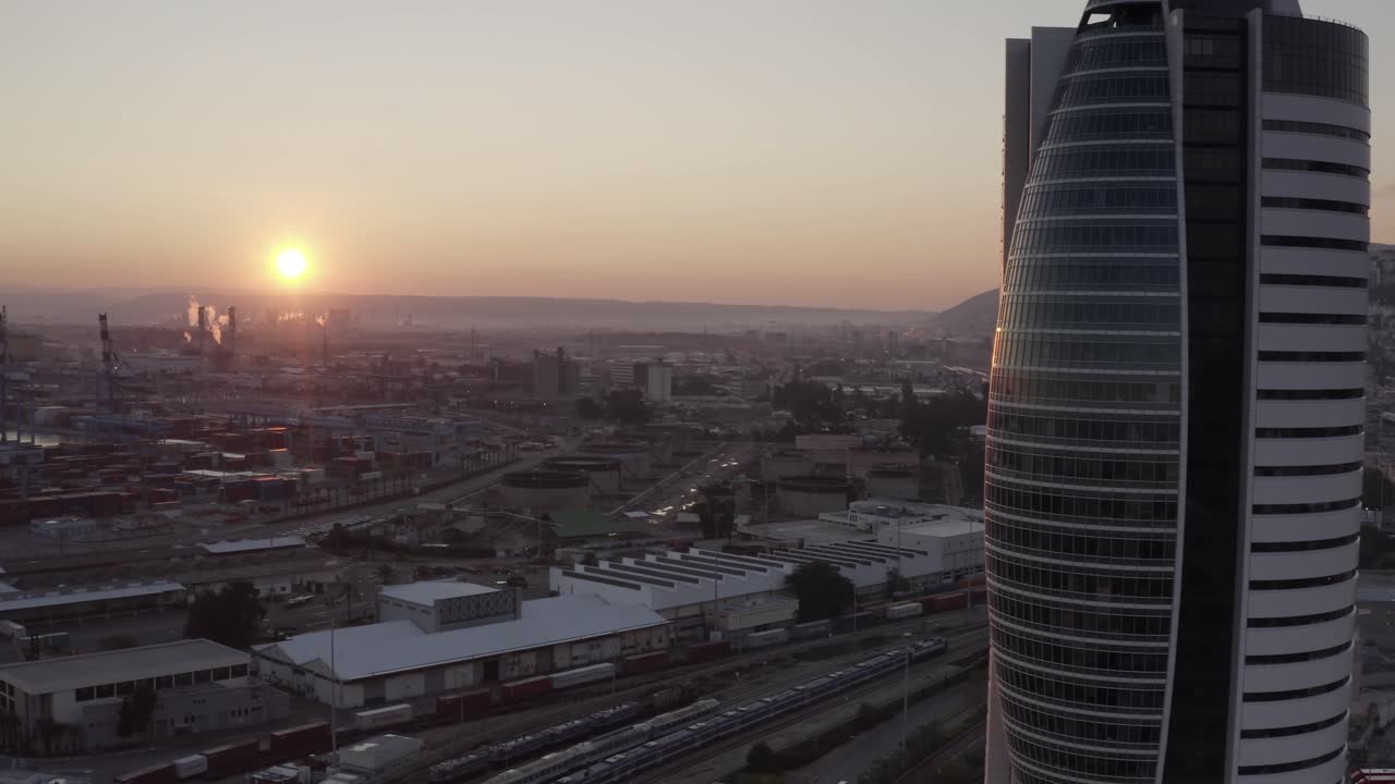 Sunrise over a modern city with an industrial port