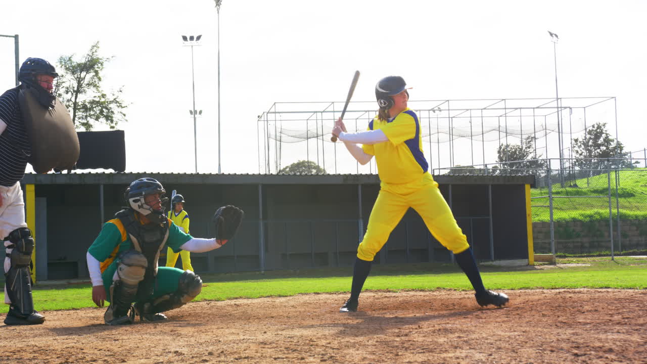 Multiracial female baseball players and male umpire, hitting the ball and running on a pitch