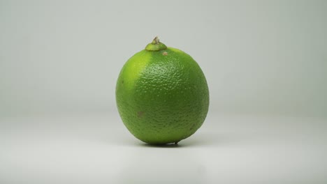 lime fruit rotating clockwise on the turntable with pure white background - close up shot