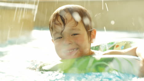 Niño-Feliz-Nadando-Con-Anillo-De-Goma-En-La-Piscina