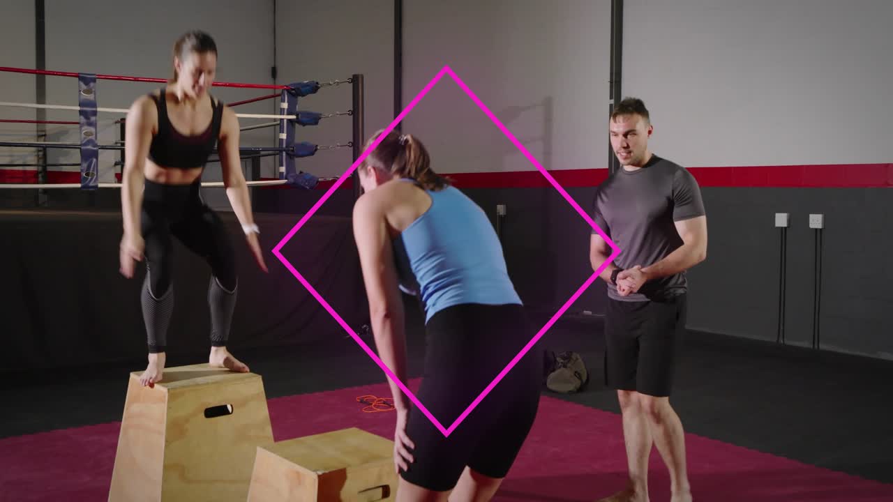 Women doing alternating box jumps while coach timing fitness reps, pink diamond overlaying pair
