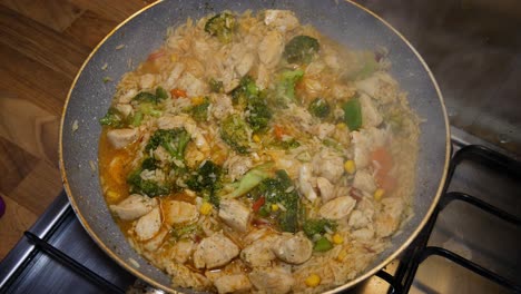 cooking chicken stew in hot pan with steam comming out