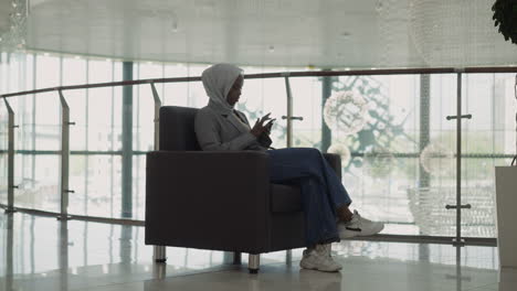 Muslimische-Geschäftsfrau-Nutzt-Mobiltelefon-Im-Bürozentrum