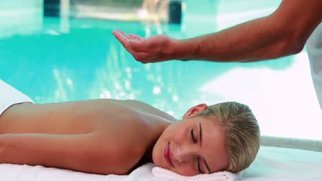 peaceful blonde getting a massage poolside
