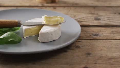 video of knife and soft cheese on plate and rustic wooden table with copy space