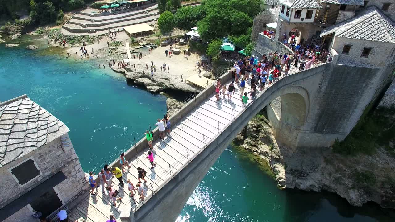 모스타르 의 다리 를 건너고 있는 사람 들 의 공중 사진