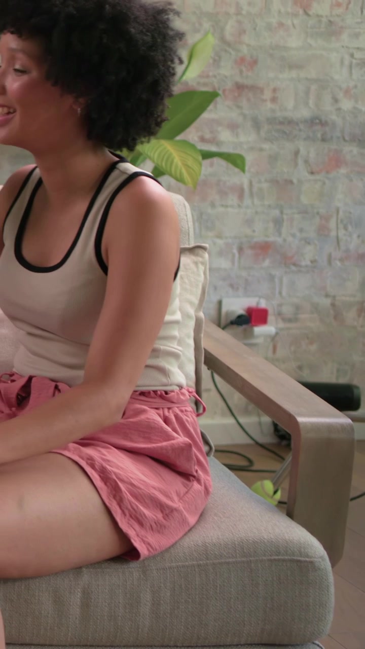 Vertical video: Moving ring light, hand showing at home while woman in tank shifting for filming