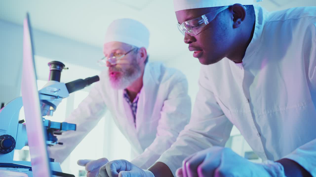Male Scientists Collaborating on Research with Laptop and Microscope