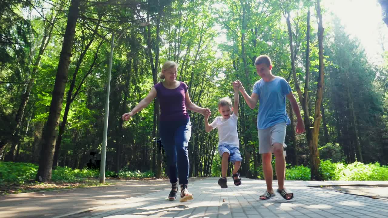 una familia de tres corre a lo largo de un callejón en el parque 02