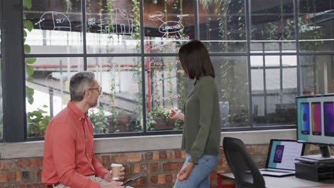 Diverse-male-and-female-colleagues-brainstorming-at-glass-wall-in-office,-slow-motion