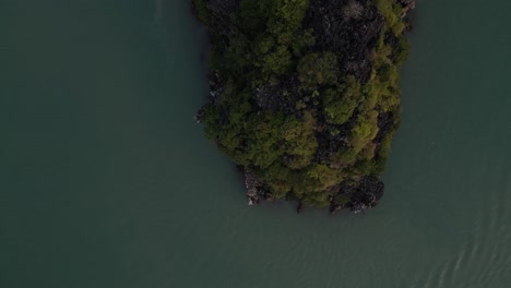 drone shot of boat floating past green islands in cat ba and halong bay in northern vietnam