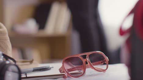 person packing suitcase for summer holiday with sunglasses and hat in foreground