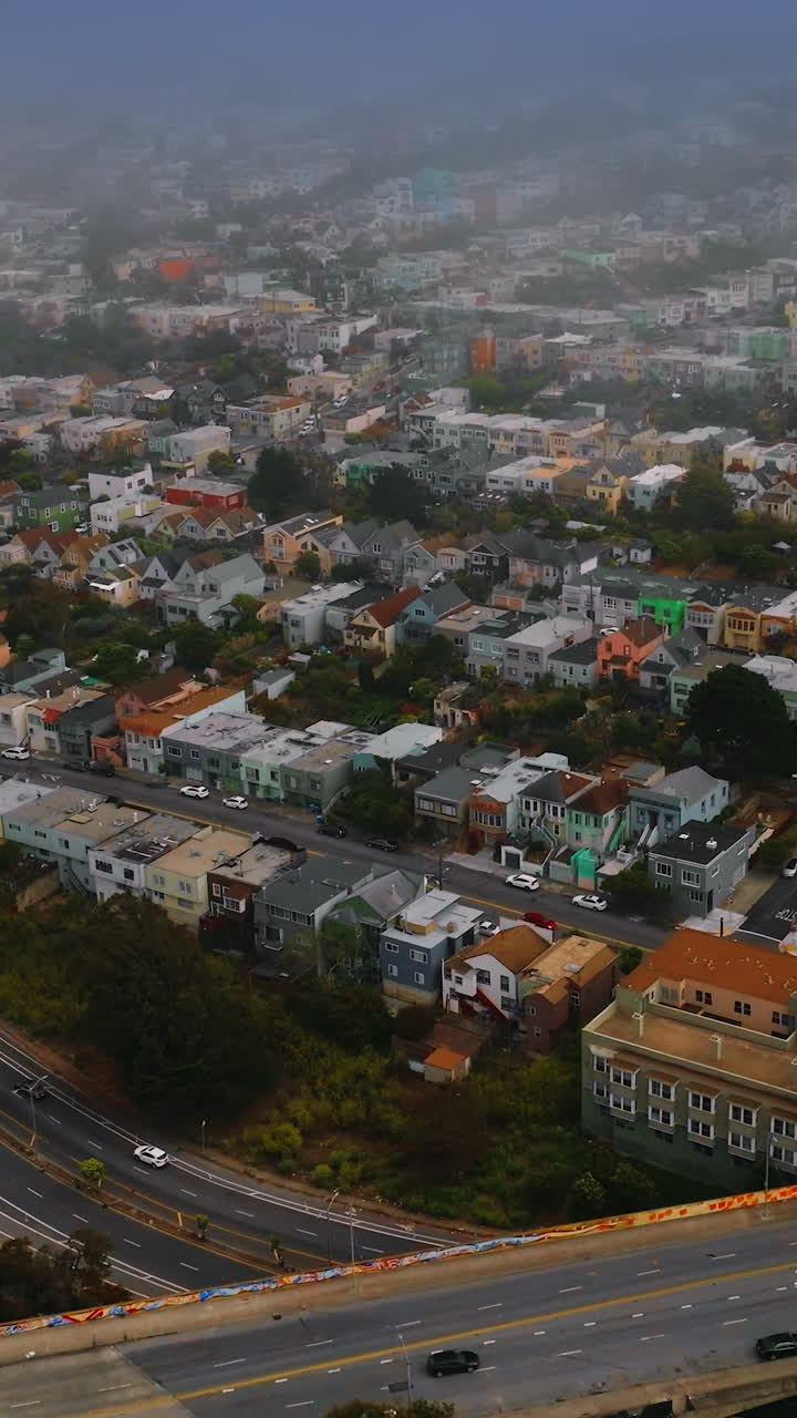 City panorama with busy traffic and lively streets. San Francisco scenery coating with fog. Aerial view. Vertical video
