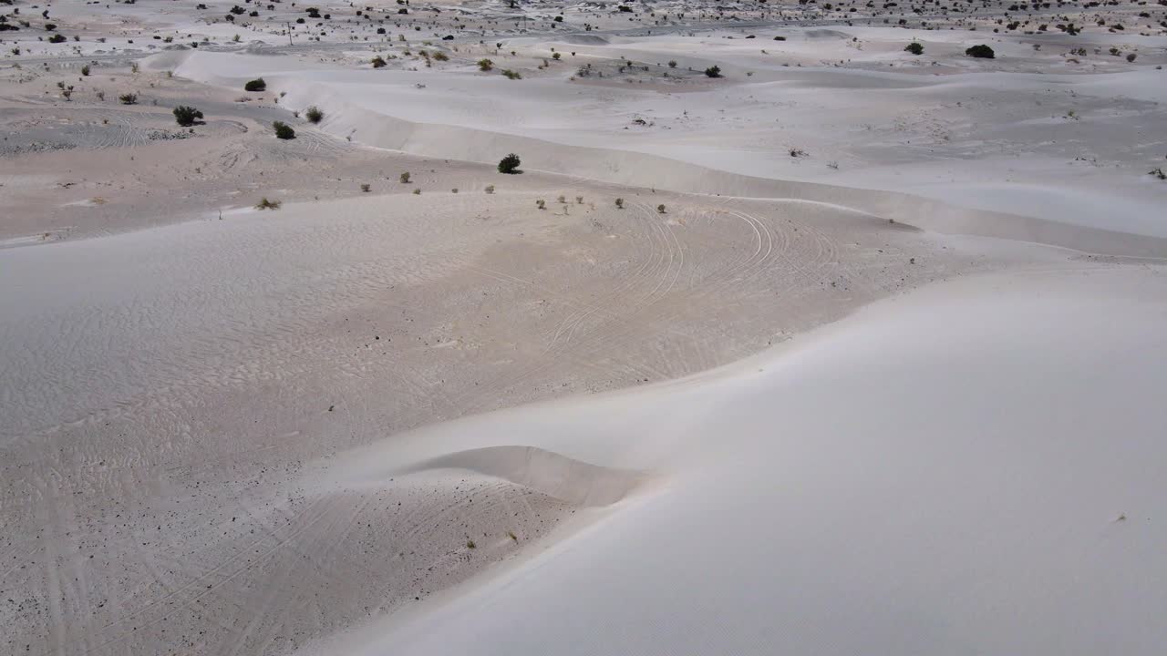 Drone shot flying over dunes in the Tat&oacute;n desert in Catamarca, Argentina while panning up to reveal mountains in the distance