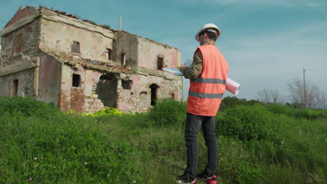 engineer on the construction site looking at the old building and taking notes