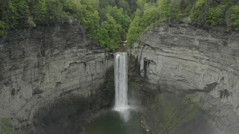 drone shot, flying backwards, showing a big waterfall in a canyon