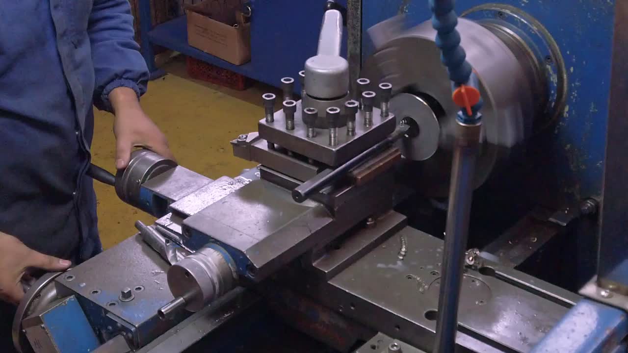 Close up footage of a worker lathing a metallic part.