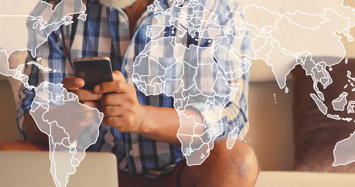Mature man on couch tapping phone causing faint world map overlay covering frame for tech data
