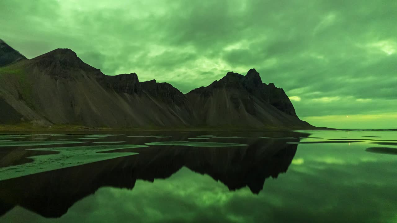 colores verdes brillantes de la aurora boreal sobre las montañas vestrahorn, islandia
