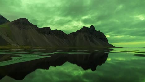 colores verdes brillantes de la aurora boreal sobre las montañas vestrahorn, islandia