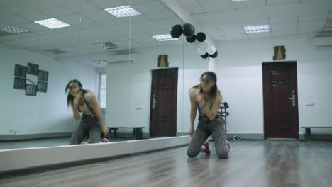 caucasian female dancer choreographer performing a freestyle dancing against a mirror wall in a dance studio