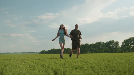 back view of happy couple jogging across vast green field holding hands under clear sky, capturing dynamic movement, joyful energy, tender connection and scenic rural backdrop