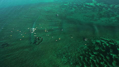 Surfers-catching-party-wave-in-Tanjung-aan-surf-reef,-Indonesia