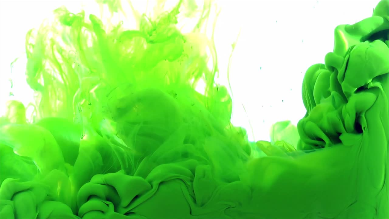 Zářivě zelený inkoust šířící se a rozpouštějící se ve vodě.