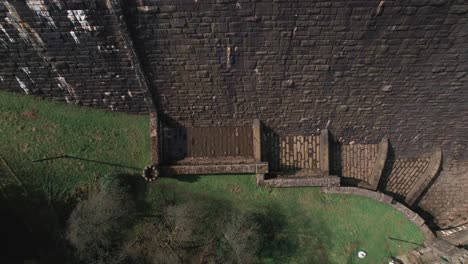 Top-down-aerial-view-rising-above-Scar-house-reservoir-infrastructure-high-angle-view-overlooking-dam-lake-water