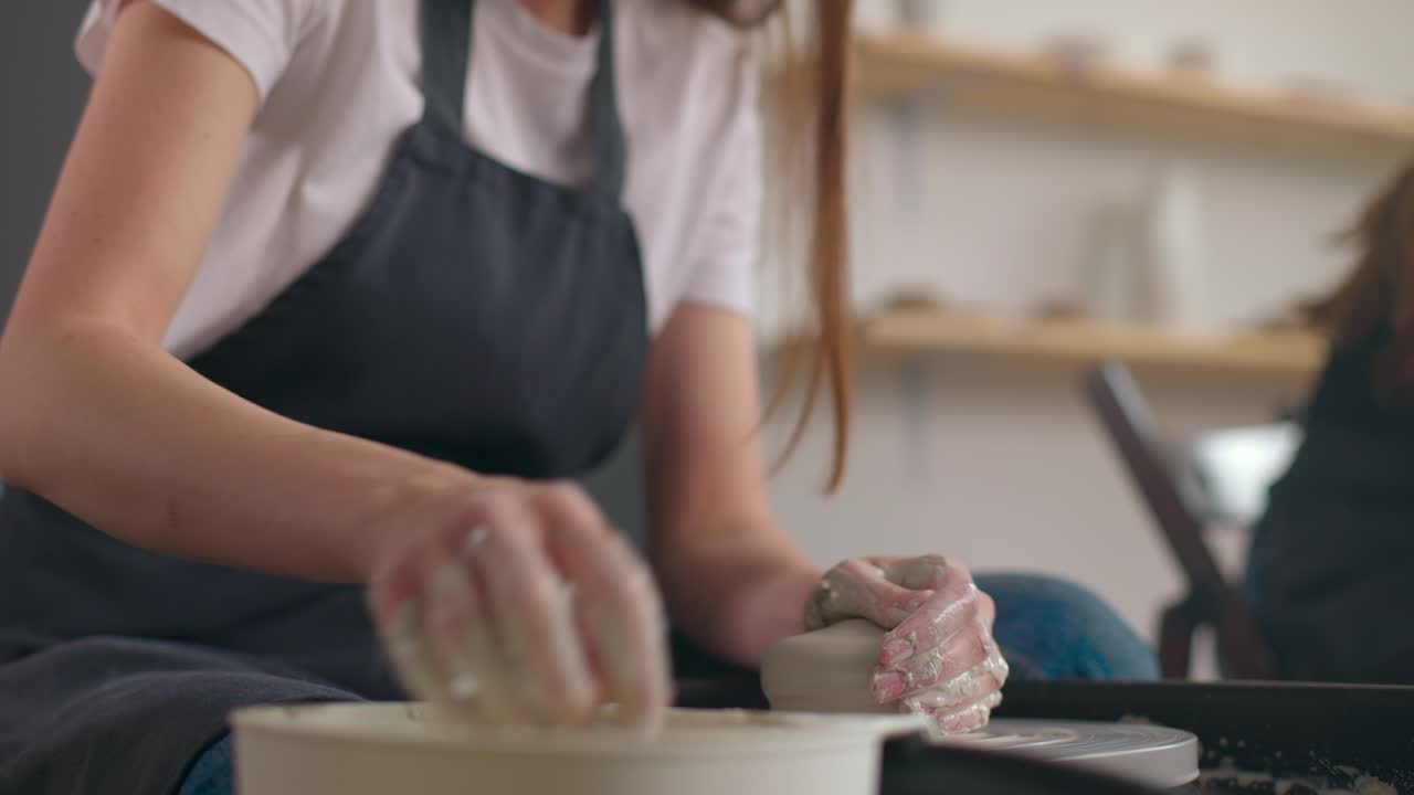 도자기 바를 사용하는 도자기 스튜디오의 젊은 여성, 수작업 세라, 창의적. 손의 클로즈업, 느린 동작