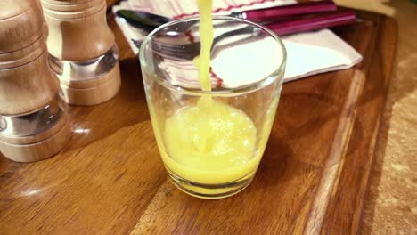 jugo de naranja en un vaso, el desayuno de la mañana, cámara lenta con seguimiento de rotación.