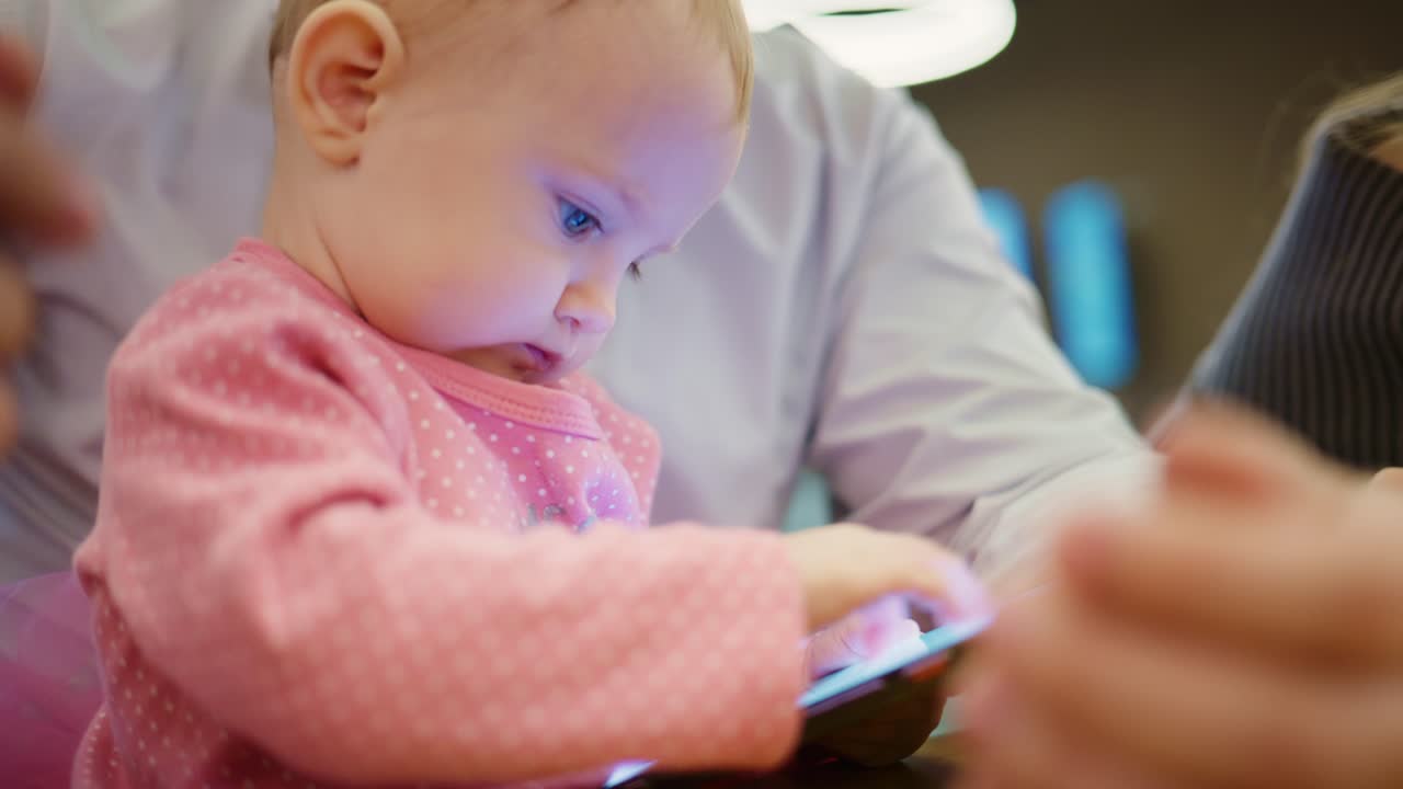 スマートフォンの画面で遊ぶ好奇心旺盛な女の子の赤ちゃん
