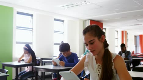 estudiantes que usan tabletas digitales en el aula