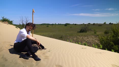 Famous-poet-Sandor-Petofi-resting-on-sand-dune,-thinking