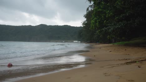 Dunkler-Blick-Auf-Den-Strand-Von-Dam-Trau-Und-Die-Wellen,-Die-An-Einem-Bewölkten-Tag-In-Con-Dao,-Vietnam,-In-Die-Küste-Rollen