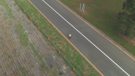 aerial view of a japanese woman jogging alone on the street in saitama, japan - drone shot