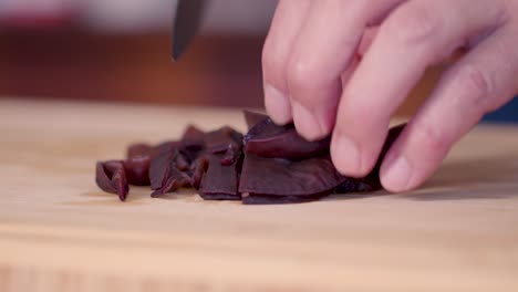 Chef-slices-wood-ear-mushrooms-with-sharp-knife,-close-up-low-angle