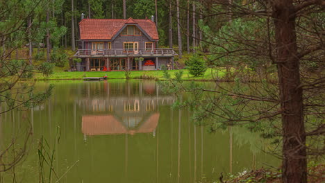 tilt down shot of beautiful lakeside lodge along spring landscape beside a lake in timelapse